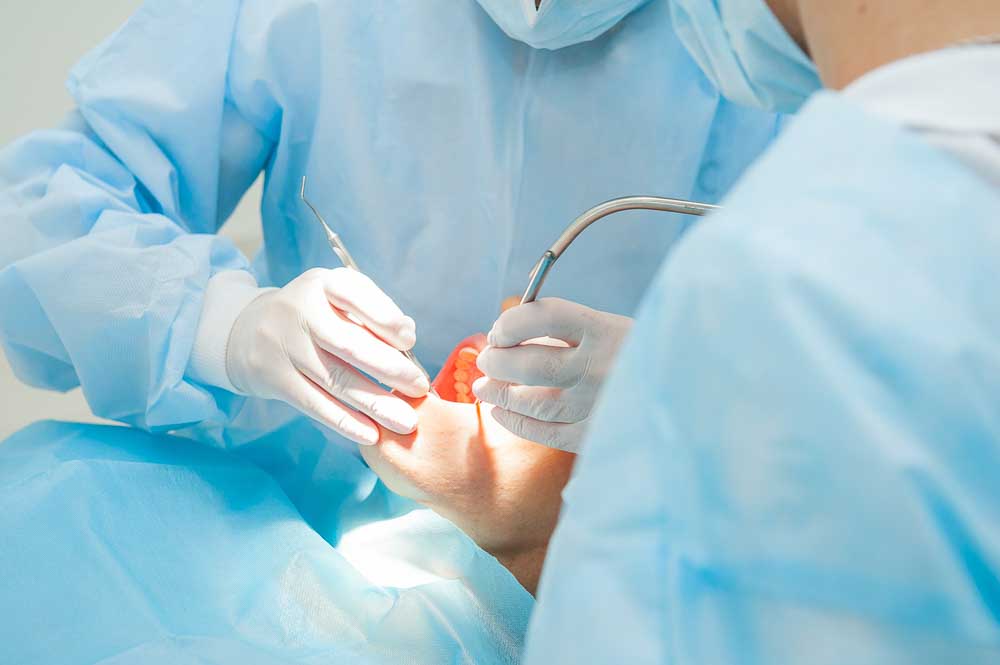 Dentist performing oral surgery and tooth extraction