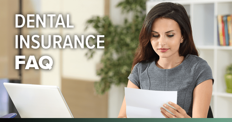 Woman in grey shirt reviewing dental insurance documents at desk with laptop nearby