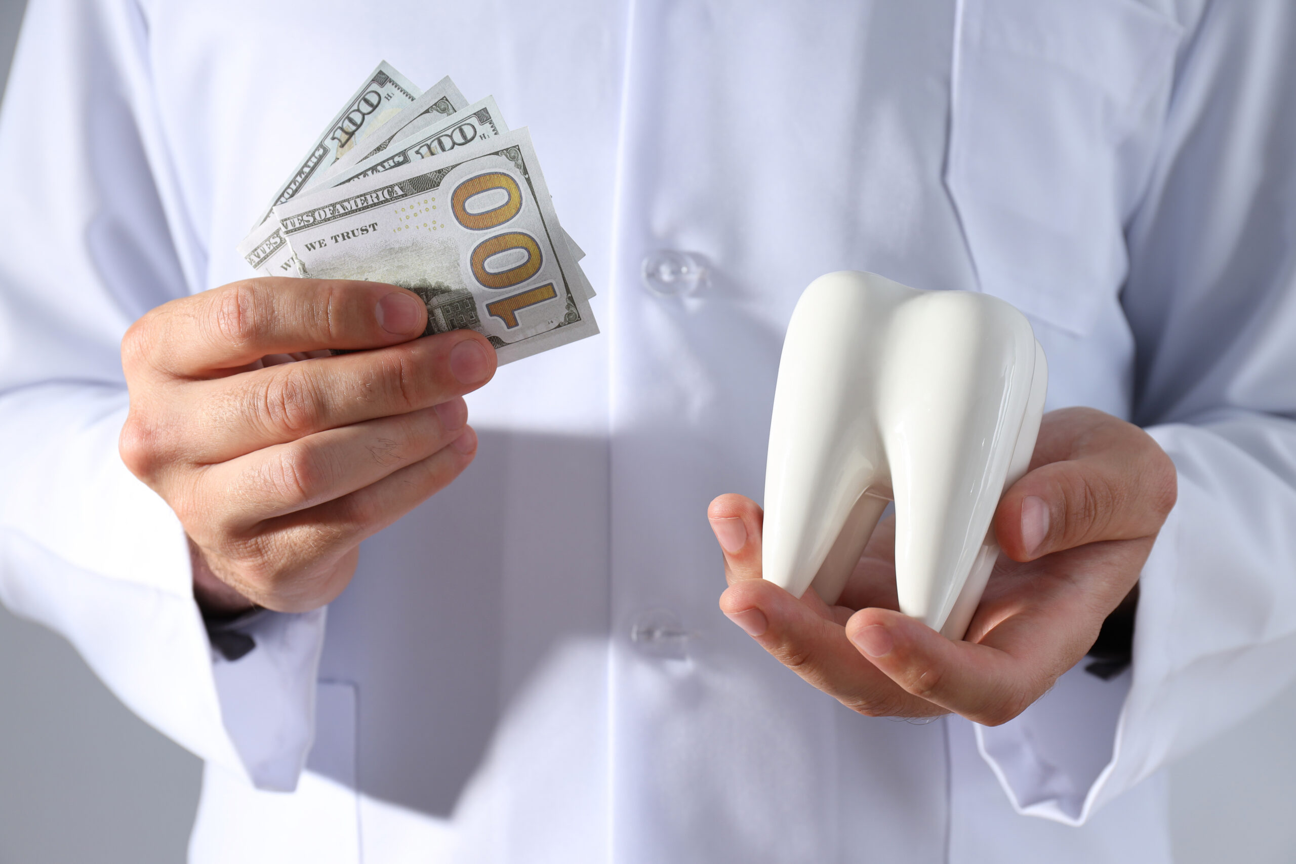 Dentist explaining treatment costs to a patient in a modern dental office