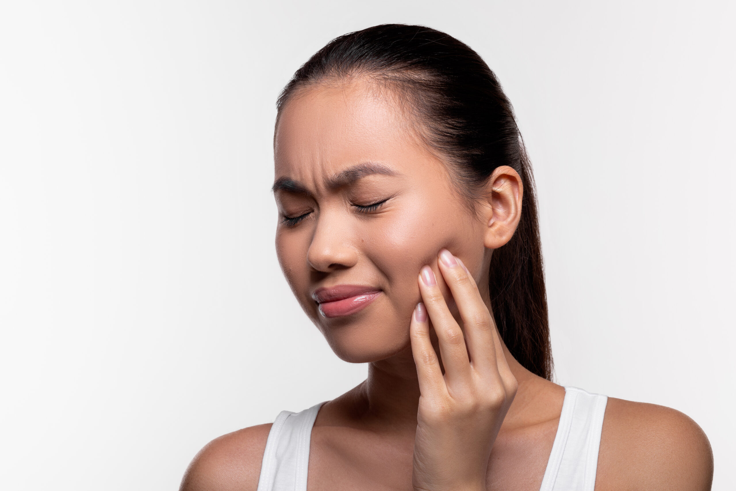 Person holding jaw in pain, illustrating toothache discomfort