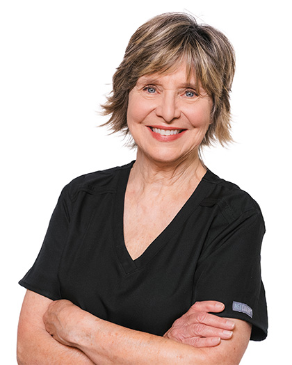 Pauline Fields, RDH – Registered dental hygienist at Pecan Tree Family Dentistry in McKinney, TX, smiling with folded arms in black scrubs.