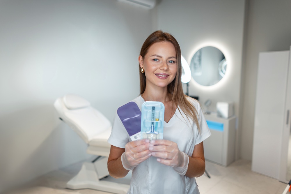Female dental professional holding in-office teeth whitening supplies in a modern dental clinic