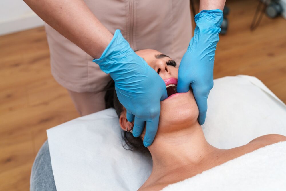 Therapist performing TMJ intraoral massage on a patient for jaw tension relief