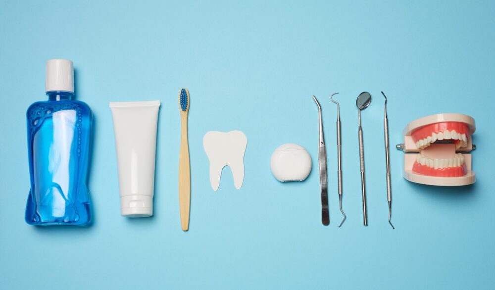 DIY vs. professional teeth whitening tools arranged on blue background – McKinney, TX